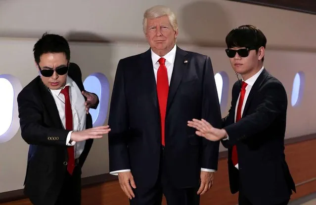 Two men dressed like bodyguards pose next to a wax figure of U.S. President-elect Donald Trump during a photo call at the Grevin Seoul Museum in Seoul, South Korea, Friday, January 20, 2017. Trump's wax figure was unveiled at the museum before his presidential inauguration. (Photo by Lee Jin-man/AP Photo)