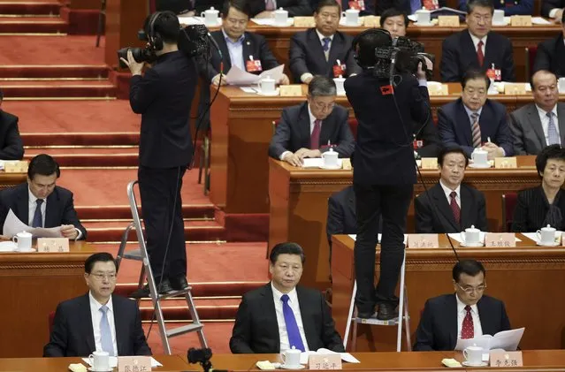 Cameramen film as China's President Xi Jinping (front, C), Premier Li Keqiang (front, R) and Chairman of the Standing Committee of the National People's Congress (NPC) Zhang Dejiang (front L) attend the opening session of the Chinese People's Political Consultative Conference (CPPCC) at the Great Hall of the People in Beijing, China, March 3, 2016. (Photo by Jason Lee/Reuters)