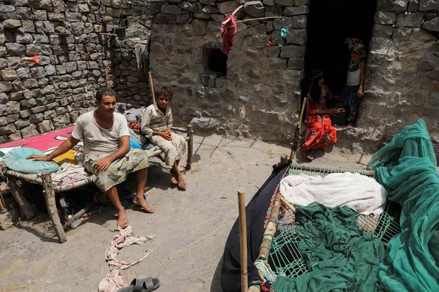 Ali al-Emadi, who works as a lumberjack, sits in his house with his family in a village in Khamis Banisaad district of al-Mahweet province, Yemen, June 24, 2021. “Should there be good quantity of wood available, we make a living, thank God. But nowadays trees are scarce”, Emadi said. “If I get something, we eat. At least we live or die together”. (Photo by Khaled Abdullah/Reuters)