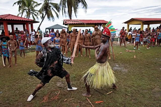 Vicente Forsythe (L) as Christopher Columbus as natives participate in the open-air staging “Indian Game” about the discovery of America, in the community of Viento Frio, Colon, Panama, 16 October 2021 (issued 18 October 2021). For more than 40 years now, a large number of the 500 or so inhabitants of the community of Viento Frio in the Costa Arriba of the Panamanian province of Colon have been involved in their interpretation of the discovery of America, with a collective, open-air staging called “Juego de indios” (Indian Game). (Photo by Bienvenido Velasco/EPA/EFE)