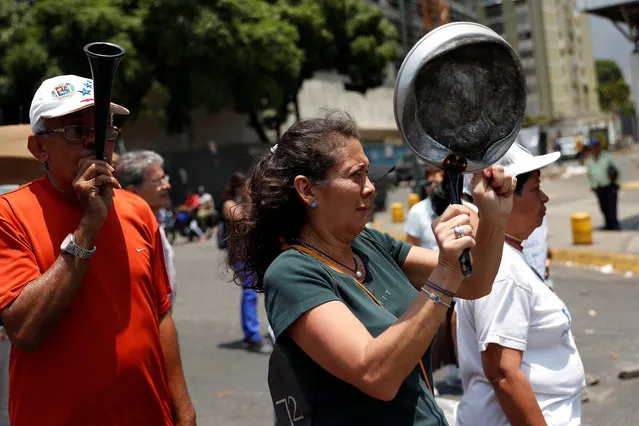 People take part in a protest against the government of Venezuela's President Nicolas Maduro in Caracas, Venezuela April 1, 2019. (Photo by Carlos Garcia Rawlins/Reuters)