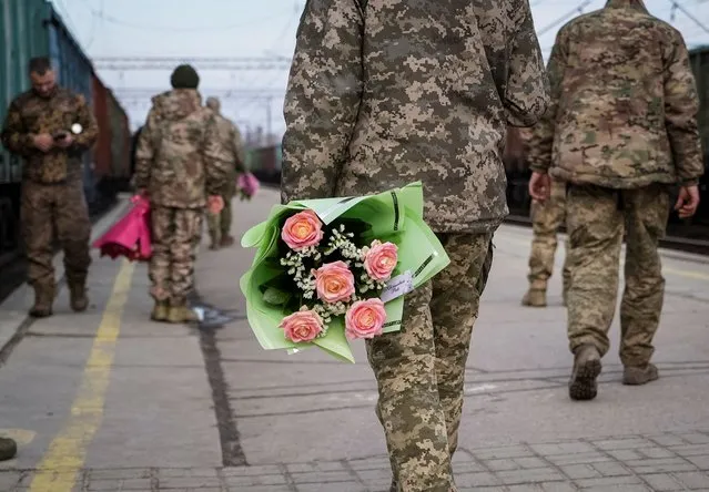 Ukrainian servicemen with flowers wait for the train from Kyiv, amid Russia's attack on Ukraine, at the train station in Kramatorsk, Ukraine on February 14, 2024. (Photo by Inna Varenytsia/Reuters)