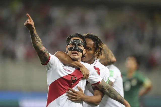 Peru's Gianluca Lapadula (9) celebrates with his teammate Andre Carrillo, after scoring his side's opening goal against Bolivia during a qualifying soccer match for the FIFA World Cup Qatar 2022 at National stadium in Lima, Peru, Thursday, November 11, 2021.(Photo by Sebastian Castaneda/Pool via AP Photo)