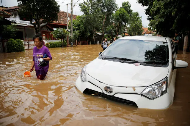 A woman wades through floodwaters in a flood-hit area in Jatinegara district, Jakarta, Indonesia, February 16, 2017. (Photo by Reuters/Beawiharta)
