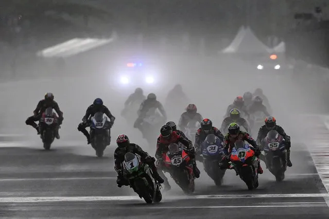 Racers ride motorbikes in the heavy rain prior to Race 2 of the Superbike World Championship at the Mandalika International Street Circuit in Lombok island, West Nusa Tenggara province, Indonesia, November 21, 2021, in this photo taken by Antara Foto. (Photo by Sigid Kurniawan/Antara Foto via Reuters)