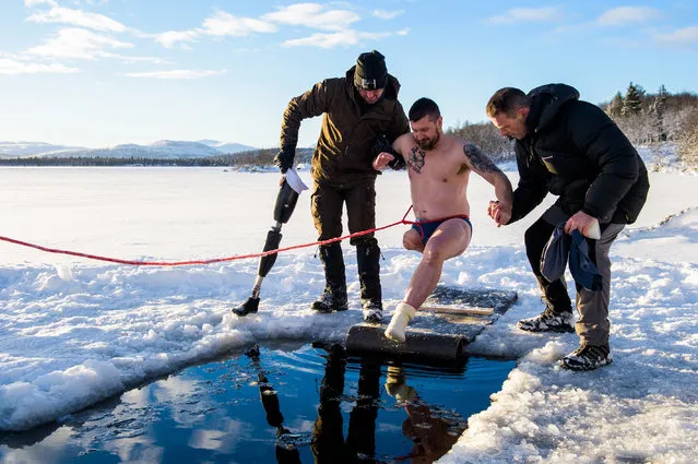 Baz Barratt enters an ice hole during a respite holiday in Norway organised by the Royal Marines Club on 4 December 2018. He lost his leg and suffered severe damage to his hands in an IED explosion in Afghanistan in 2008. (Photo by Anthony Upton/PA Wire)
