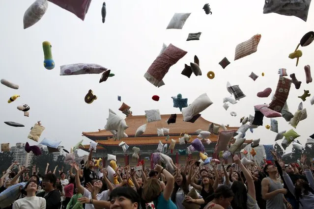 Participants throw their pillows during the International Pillow Fight Day at Liberty Square, in Taipei, Taiwan April 2, 2016. (Photo by Tyrone Siu/Reuters)