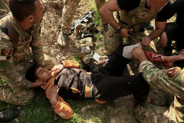 Rapid Response forces members surround an injured boy as they are treat him during a battle with Islamic State's militants south west Mosul, Iraq February 24, 2017. (Photo by Zohra Bensemra/Reuters)