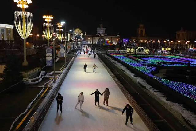 People skate during the opening of a skating rink at VDNKh, The Exhibition of Achievements of National Economy, in Moscow, Russia, on Friday, November 26, 2021. The area of artificial ice cover is more than 20,000 sq. meters. (Photo by Alexander Zemlianichenko Jr./AP Photo)