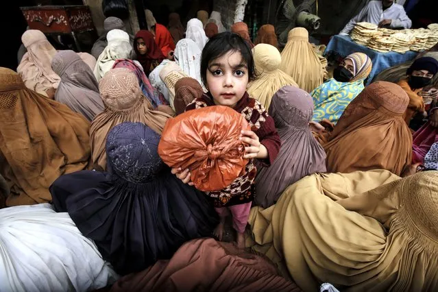 Burqa-clad women and children wait to receive free food distributed by locals to break their fast, during the fasting month of Ramadan in Peshawar, Pakistan, 19 March 2024. The Muslims' holy month of Ramadan is the ninth month in the Islamic calendar and it is believed that the revelation of the first verse in the Koran was during its last 10 nights. It is celebrated yearly by praying during the night time and abstaining from eating, drinking, and sеxual acts during the period between sunrise and sunset. It is also a time for socializing, mainly in the evening after breaking the fast and a shift of all activities to late in the day in most countries. (Photo by Bilawal Arbab/EPA/EFE)