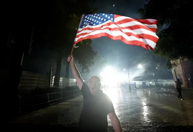 An opposition supporter holds a U.S. flag outside Parliament building during an anti-government protest, calling on Prime Minister Edi Rama to step down, in Tirana, Albania, June 8, 2019. (Photo by Florion Goga/Reuters)