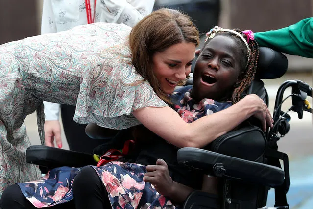 Britain's Catherine, Duchess of Cambridge hugs a girl in a wheelchair as she joins a photography workshop with Action for Children in Kingston upon Thames, Britain, June 25, 2019. (Photo by Chris Jackson/Pool via Reuters)