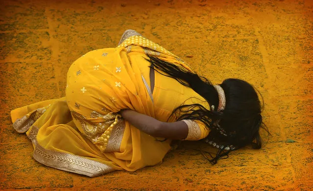 In this Monday, June 3, 2019, photo, a devotee covered in the spice turmeric goes into a trance during the celebration of the Bhandara Festival, or the Festival of Turmeric, at the Jejuri temple in Pune district, Maharashtra state, India. During the festival, devotees use the golden powder to worship the deity Lord Khandoba, widely known as a descendant of the sun, and to celebrate his victory over the demons Mani and Malla. (Photo by Rafiq Maqbool/AP Photo)