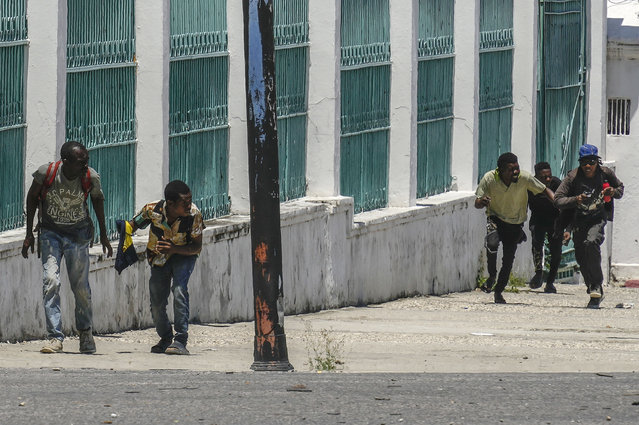 People run for cover as shots ring near the National Palace, in Port-au-Prince, Haiti, Tuesday, April 30, 2024. (Photo by Ramon Espinosa/AP Photo)