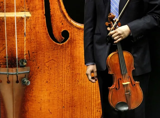 Hong Kong violist Andrew Ling holds a rare 1719 viola called the “Macdonald” by Antonio Stradivari during a preview at the Sotheby's auction house in Hong Kong, on April 4, 2014. The Stradivarius viola is expected to sell for more than $45 million in a private sale. The auction house says that price would be a record for a musical instrument sold privately or at auction. (Photo by Kin Cheung/Associated Press)