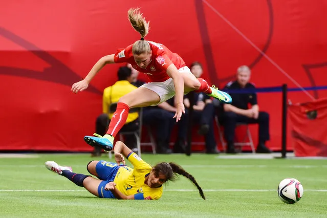 Switzerland midfielder Ana Maria Crnogorcevic (13) jumps over Ecuador defender Nancy Aguilar (3) in Vancouver, June 12, 2015. (Photo by Anne-Marie Sorvin/USA TODAY Sports)