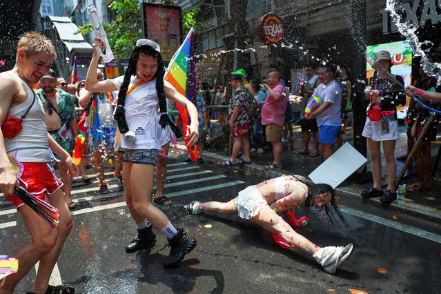 Revellers dance and play with water during a gay parade as they celebrate the Songkran holiday which marks the Thai New Year in Bangkok, Thailand, on April 14, 2024. (Photo by Chalinee Thirasupa/Reuters)