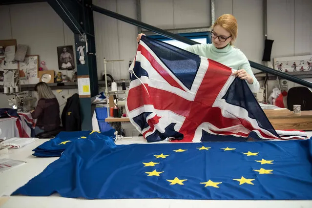 A flag manufacturer folds finished Union Flags and EU flags at the factory of “Flagmakers” in Chesterfield, northern England on March 24, 2017. The British government has announced its intention to trigger the Article 50 clause to begin the UK' s withdrawl from the European Union (EU) on March 29. (Photo by Oli Scarff/AFP Photo)