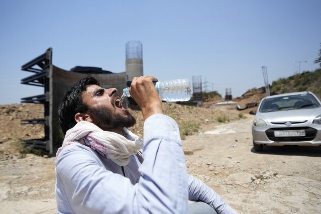 A man drinks water on a hot summer day in Jammu, India, Monday, May 27, 2024. (Photo by Channi Anand/AP Photo)