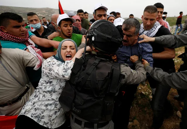 Palestinians try to prevent Israeli troops from detaining a protester during a protest marking Land Day in the West Bank village of Madama, near Nablus March 30, 2017. (Photo by Mohamad Torokman/Reuters)