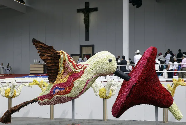A hummingbird covered in flowers decorates the stage by the altar where Pope Francis celebrates Mass at Bicentennial Park in Quito, Ecuador, Tuesday, July 7, 2015. Francis told an estimated half-million people gathered for the Mass that in a world divide by wars, violence and individualism, Catholics should be “builders of unity”, bringing together hopes and ideals of their people. (Photo by Gregorio Borgia/AP Photo)