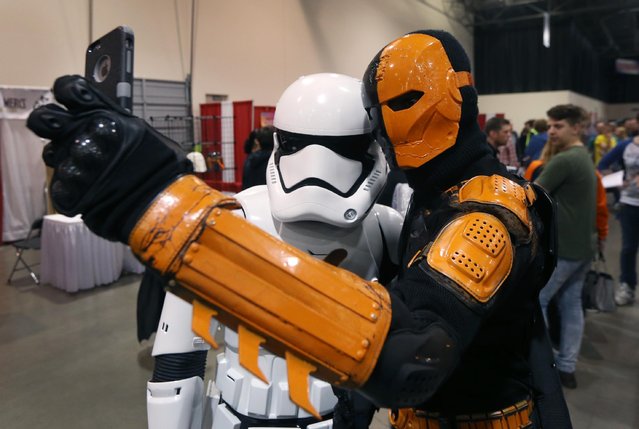 Benzy Deviveau, dressed as Deathstroke, right, takes a selfie with Ted Ruler, a Star Wars Stormtrooper, at the Suburban Collection Showcase, Friday, May 15, 2015, in Novi, Mich. The three-day pop-culture extravaganza will welcome dozens of celebrities from the worlds of TV, film and beyond as well as thousands of fans. (Photo by Carlos Osorio/AP Photo)