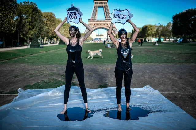 Activistst for animal rights group People for the Ethical Treatment of Animal (PETA) douse themselves with black product while holding placards reading “Leave leather” and “Leather is a dirty bussiness”, during a protest against the use of leather in the fashion industry on September 23, 2019 in front of the Eiffel tower in Paris. (Photo by Stephane De Sakutin/AFP Photo)