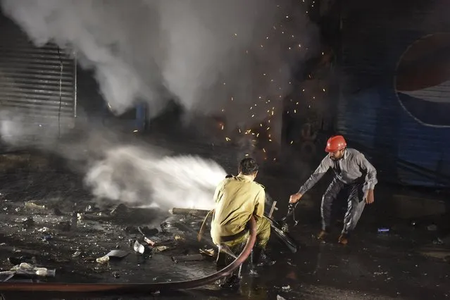Firefighters try to extinguish fire at the site of an explosion, which killed three people and wounded several others according to media reports, at a market area in Quetta on March 2, 2022. (Photo by Banaras Khan/AFP Photo)