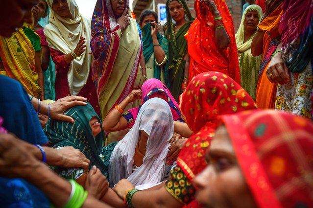 Relatives mourn outside of the home of three victims of same family who died in a stampede on July 03, 2024 in Sokna village on July 03, 2024 in Hathras, India. At least 116 people were confirmed killed in a devastating stampede at a Satsang, or religious event, in Hathras, in India's densely populated Uttar Pradesh state on Tuesday. The stampede occurred as the event concluded and attendees were trying to exit, with the narrow exit leading to a deadly crush of the large crowd. Officials expected the death toll to continue climbing rapidly through the night. (Photo by Ritesh Shukla/Getty Images)