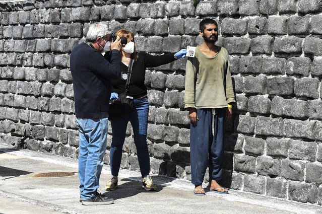 Migrants are identified by Italian authorities as they disembark from a ship in the Sicilian port of Catania, Wednesday, April 12, 2023. Italy's right-wing government has declared a state of emergency to help it cope with a surge in migrants arriving on the country's southern shores. Premier Giorgia Meloni and her Cabinet on Tuesday, decided to impose the emergency status for six months. (Photo by Salvatore Cavalli/AP Photo)