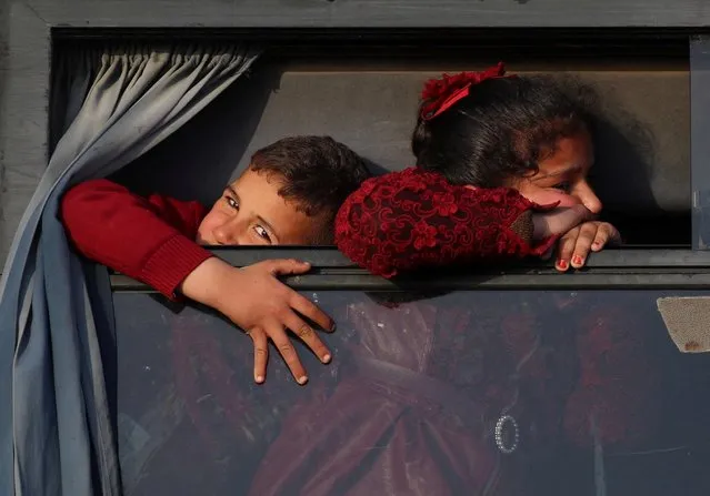 Palestinian children look out of a bus window in Gaza city, March 27, 2022. (Photo by Mohammed Salem/Reuters)