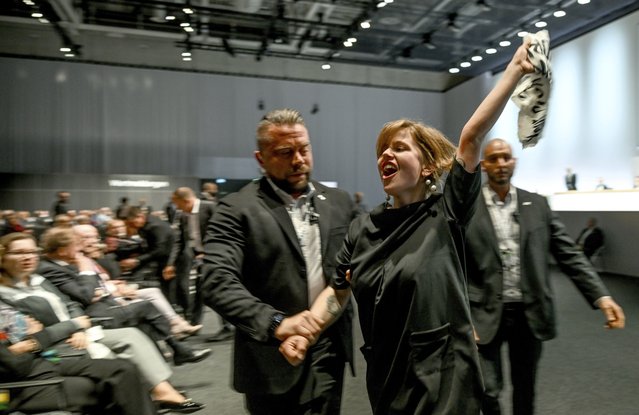 Climate activists are taken out of the venue of the annual shareholders' meeting of the Volkswagen AG in Berlin, Germany, Wednesday, May 10, 2023. (Photo by Britta Pedersen/dpa via AP Photo)