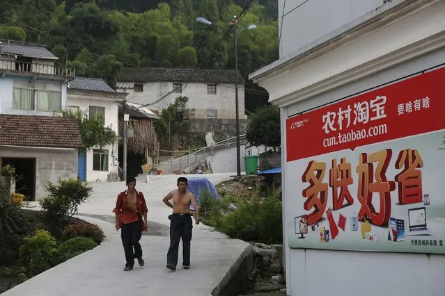 Villagers walk past an Alibaba rural service centre in Jinjia Village, Tonglu, Zhejiang province, China, July 20, 2015. (Photo by Aly Song/Reuters)