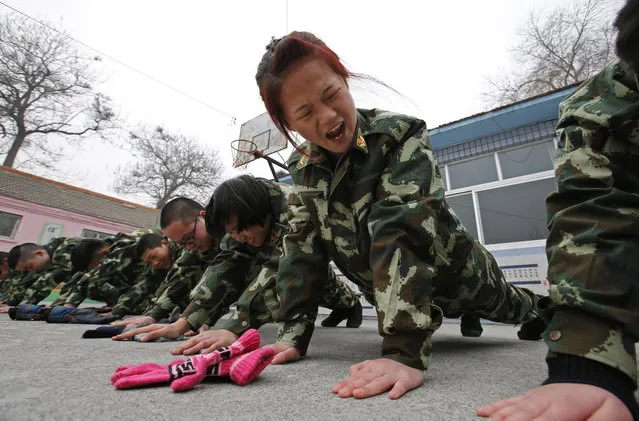 Students receive a group punishment during a military-style close-order drill class at the Qide Education Center in Beijing February 19, 2014. The Qide Education Center is a military-style boot camp which offers treatment for internet addiction. (Photo by Kim Kyung-Hoon/Reuters)