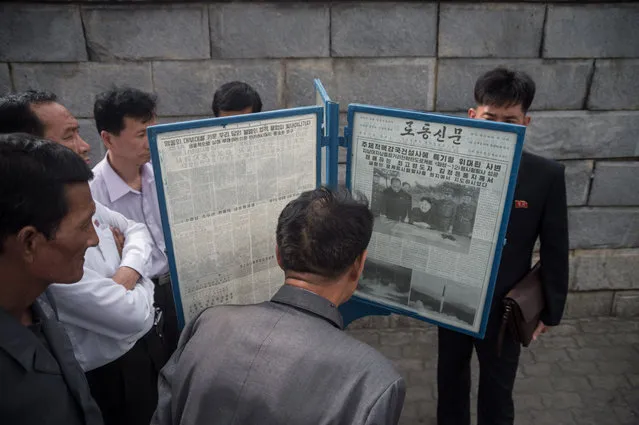 In a photo taken on May 15, 2017 people gather at a street- side newsstand showing a copy of the Rodong Sinmun newspaper featuring coverage of a May 14 North Korean rocket test, in Pyongyang The UN Security Council on May 15 strongly condemned North Korea' s latest ballistic missile test and vowed strong measures, including sanctions, to derail Pyongyang' s nuclear weapons' programme. North Korea' s long- term bid to develop a credible nuclear attack threat to the US mainland saw it launch what appeared to be its longest- range missile yet. Pyongyang said the new weapon – called the Hwasong-12 – was capable of carrying a “heavy nuclear warhead”. (Photo by Kim Won-Jin/AFP Photo)