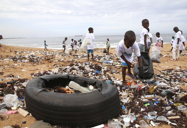 Members of an environmental NGO cleans plastic debris on Vridi beach, a popular tourist destination in the city of Abidjan, Ivory Coast, 04 June 2022, a day before World Environment Day. In 1972, the United Nations General Assembly designated 05 June as World Environment Day (WED). The first celebration, under the slogan 'One Planet Earth', took place in 1974. Over the years, the World Environment Day has become a global platform facilitating awareness and initiative to respond to urgent challenges, whether it's marine pollution, global warming, sustainable consumption or wildlife crime. Millions of people have taken part over the years and have helped change our consumption habits, as well as national and international environmental policies. (Photo by Legnan Koula/EPA/EFE)