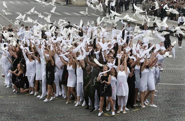 Youths release doves at the end of the traditionall Bastille Day parade on the Champs Elysees in Paris, July 14, 2014. The year 2014 marks the 100th anniversary of the start of the First World War. (Photo by Benoit Tessier/Reuters)
