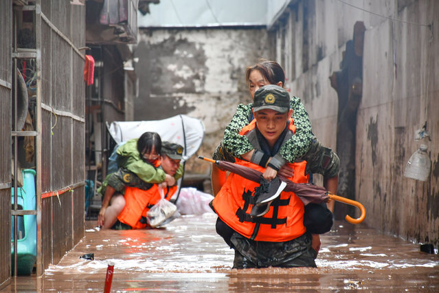 Members of the Chinese People's Armed Police Force transfer flood-trapped residents in Wanzhou District, southwest China's Chongqing Municipality, July 4, 2023. Water levels of seven rivers in southwest China's megacity of Chongqing the warning level as of 8 a.m. Tuesday after torrential downpours have battered most parts of the city since July 3, local authorities said Tuesday. (Photo by Xinhua News Agency/Rex Features/Shutterstock)