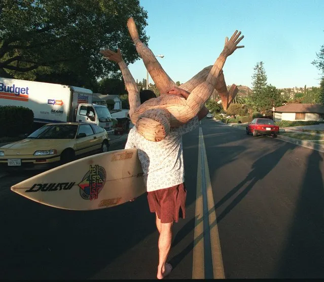 Vince Nalbone walks down the street of his Diamond Bar, Calif. neighborhood Thursday, June 27, 1996, carrying his surfboard and a toothpick sculpture of a surfer. Nalbone built the statue over five years during his spare time as a resident at County-USC Medical Center. Nalbone, who is in the midst of moving, was carrying his belongings to the moving truck. (Photo by Susan Sterner/AP Photo)