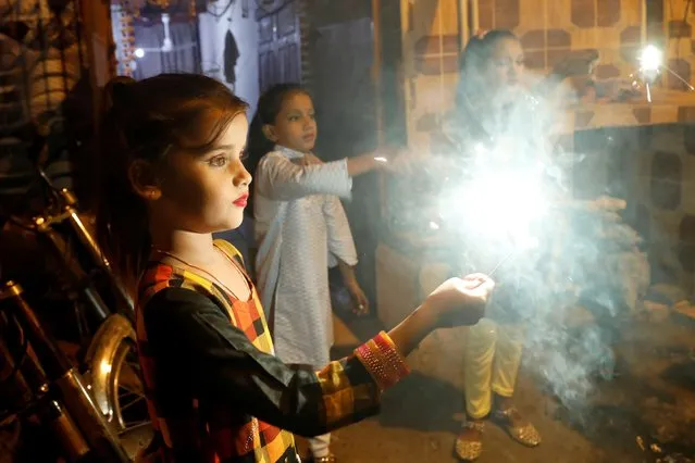 Girls hold burning sparklers during Diwali, the Hindu festival of lights, in Karachi, Pakistan on November 4, 2021. (Photo by Akhtar Soomro/Reuters)