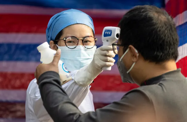 Medical personnel checks people body temperature at a roadblock in Guangzhou, China, 13 February 2020. On 12 February Hubei province recorded the largest single-day spike in coronavirus-related deaths, with 242 victims and 14,840 people diagnosed with Covid-19. The disease caused by the SARS-CoV-2 has been officially named Covid-19 by the World Health Organization (WHO). The outbreak, which originated in the Chinese city of Wuhan, has so far killed at least 1,369 people with over 60,000 infected worldwide, mostly in China. (Photo by Alex Plavevski/EPA/EFE)