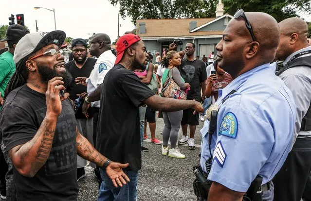 Area residents talk to police after a shooting incident in St. Louis, Missouri August 19, 2015. Police fatally shot a black man they say pointed a gun at them, drawing angry crowds and recalling the racial tensions sparked by the killing of an unarmed African-American teen in nearby Ferguson, Missouri, just over a year ago. (Photo by Lawrence Bryant/Reuters)