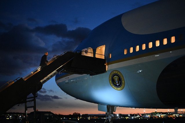 US President Joe Biden (L) boards Air Force One before departing Manchester-Boston Regional Airport in Manchester, New Hampshire on November 16, 2021. Joe Biden earlier visited a creaky bridge in New Hampshire to tout his rare victory in passing a bipartisan infrastructure package, hoping the $1 trillion measure will also put his own presidency back on the road. (Photo by Mandel Ngan/AFP Photo)