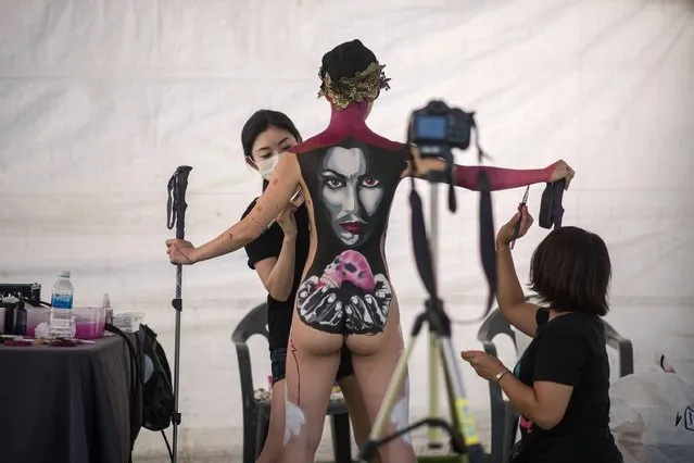 In this photo taken on August 26, 2017, contestants apply their designs to a model during the Daegu International Bodypainting Festival in Daegu. (Photo by Ed Jones/AFP Photo)