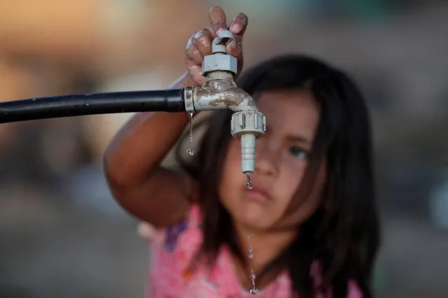 A child of the indigenous Wichi community opens a water tap, in the Salta province, Argentina, February 28, 2020. In Argentina, once one of the world s richest countries and long a major supplier of beef, children in a small indigenous community plagued by extreme poverty are dying of malnutrition and a lack of access to clean drinking water. (Photo by Ueslei Marcelino/Reuters)