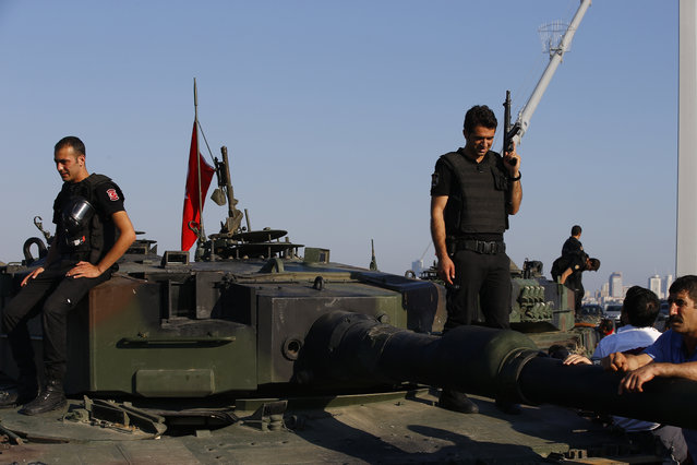 Turkish police officers, loyal to the government, stand atop tanks abandoned by Turkish army officers, near Istanbul's iconic Bosporus Bridge, Saturday, July 16, 2016. (Photo by Emrah Gurel/AP Photo)