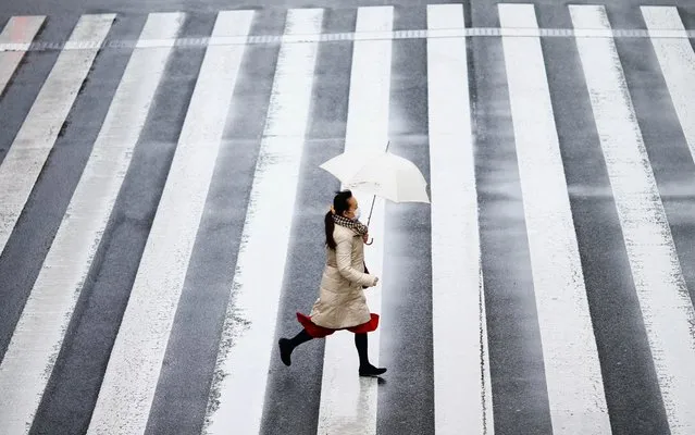 A woman wearing a protective face mask, following an outbreak of the coronavirus disease (COVID-19), runs on a street near Tamachi station in Tokyo, Japan on March 8, 2020. (Photo by Edgard Garrido/Reuters)