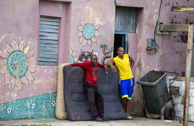 Men lean against their mattresses during a pause from securing their belongings before the arrival of Hurricane Irma in Caibarien, Cuba, Friday, September 8, 2017. Cuba evacuated tourists from beachside resorts after Hurricane Irma left thousands homeless on a devastated string of Caribbean islands and spun toward Florida for what could be a catastrophic blow this weekend. (Photo by Desmond Boylan/AP Photo)