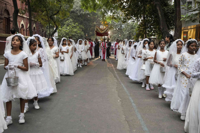 Flower girls carrying flower pots lead the annual Corpus Christi procession organised by the Catholic Association of Bengal, in Kolkata, India, Sunday, November 24, 2024. (Photo by Bikas Das/AP Photo)