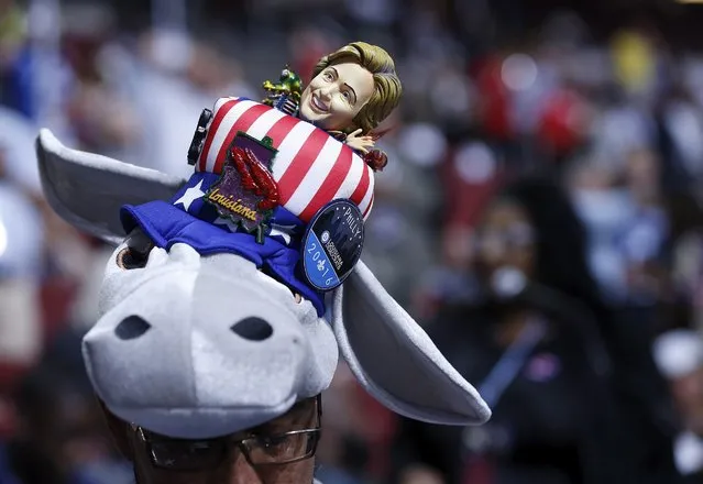 A delegate with a hat incorporating the Democratic donkey mascot and a figurine of Democratic U.S. presdential candidate Hillary Clinton sits on the floor at the Democratic National Convention in Philadelphia, Pennsylvania, U.S. July 25, 2016. (Photo by Tannen Maury/EPA)
